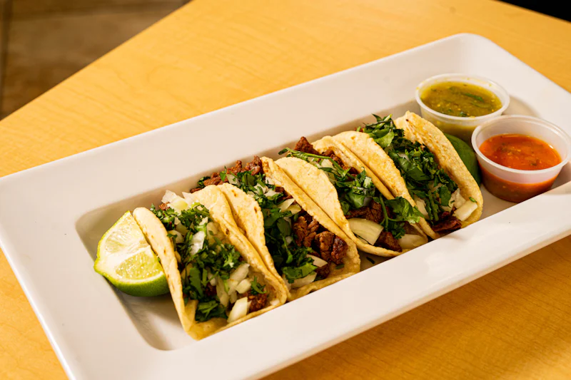 Tacos al pastor with cilantro and onion on handmade tortillas