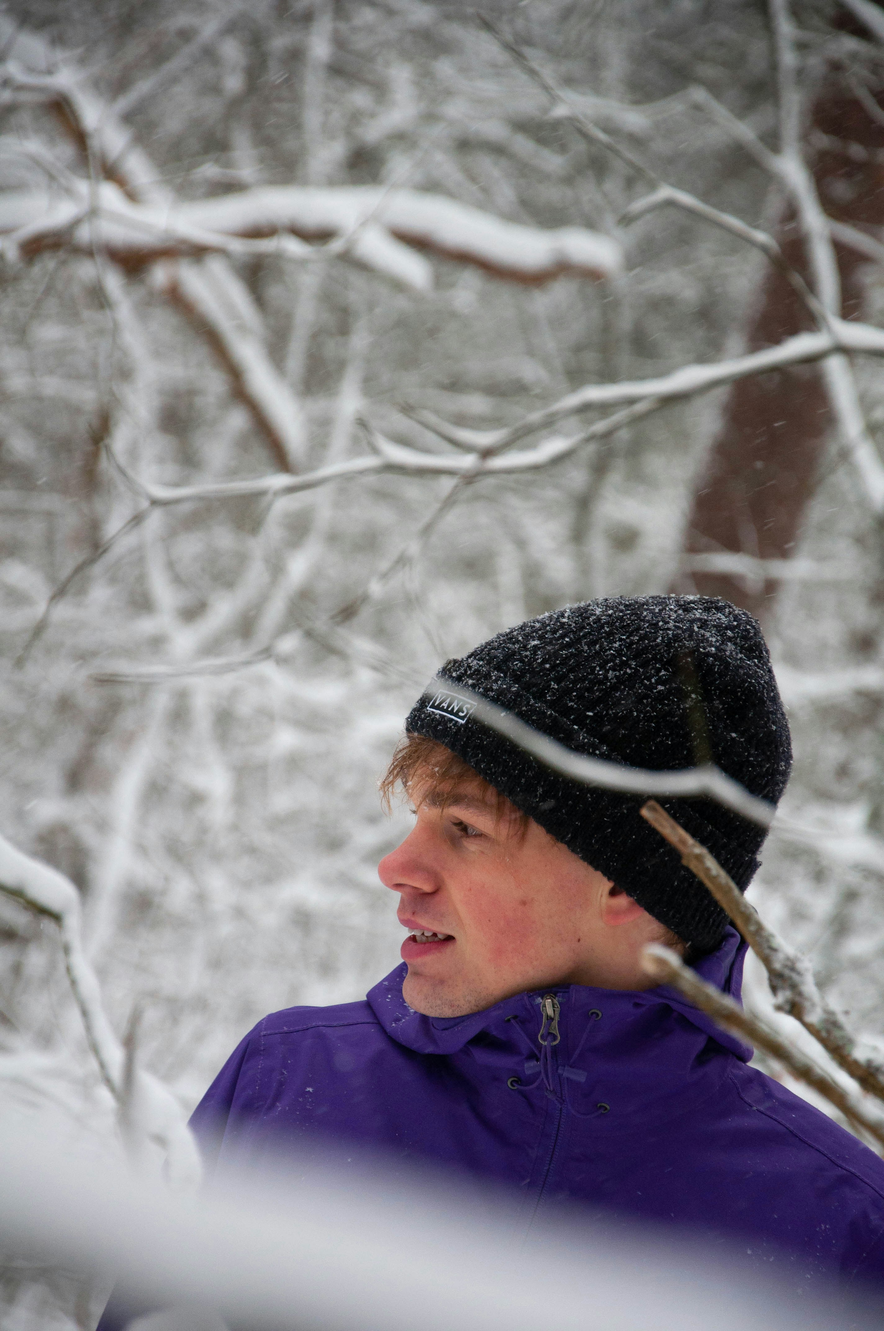 man in blue jacket and black knit cap standing near trees during daytime