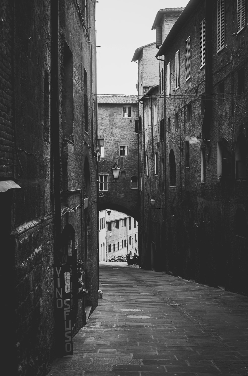 grayscale photo of alley between buildings