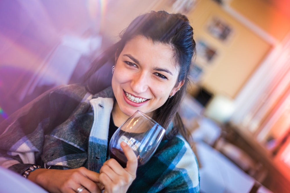 smiling woman holding clear drinking glass
