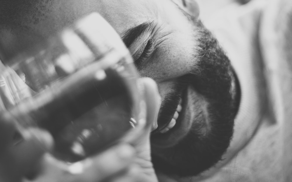 man holding clear drinking glass