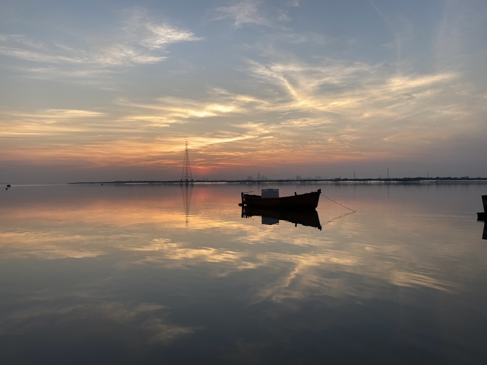 bateau sur mer calme au coucher du soleil