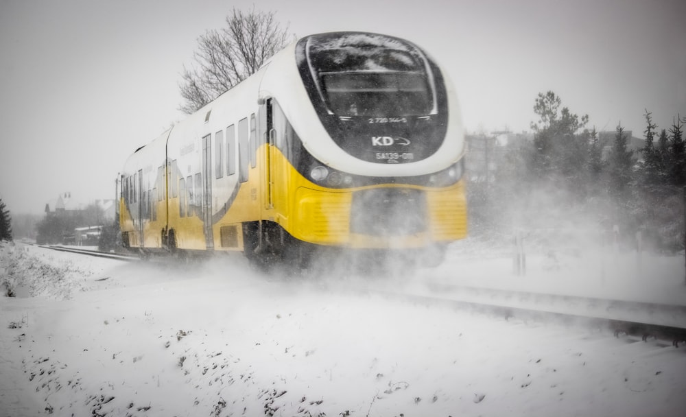 yellow and white train on snow covered ground
