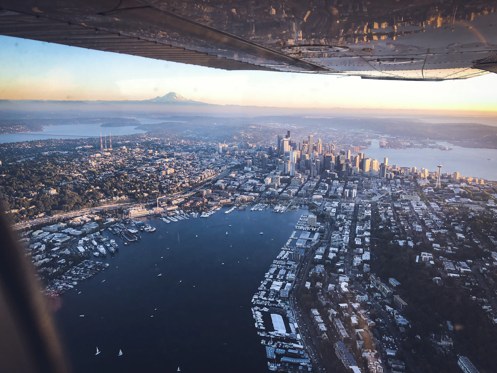 View from a seaplane wing over Lake Union and downtown Seattle with Mount Rainier hazy on the horizon