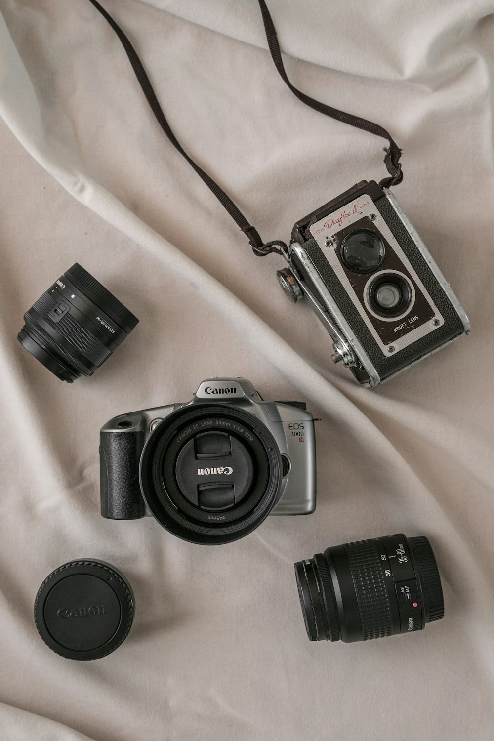 black and silver dslr camera on white textile