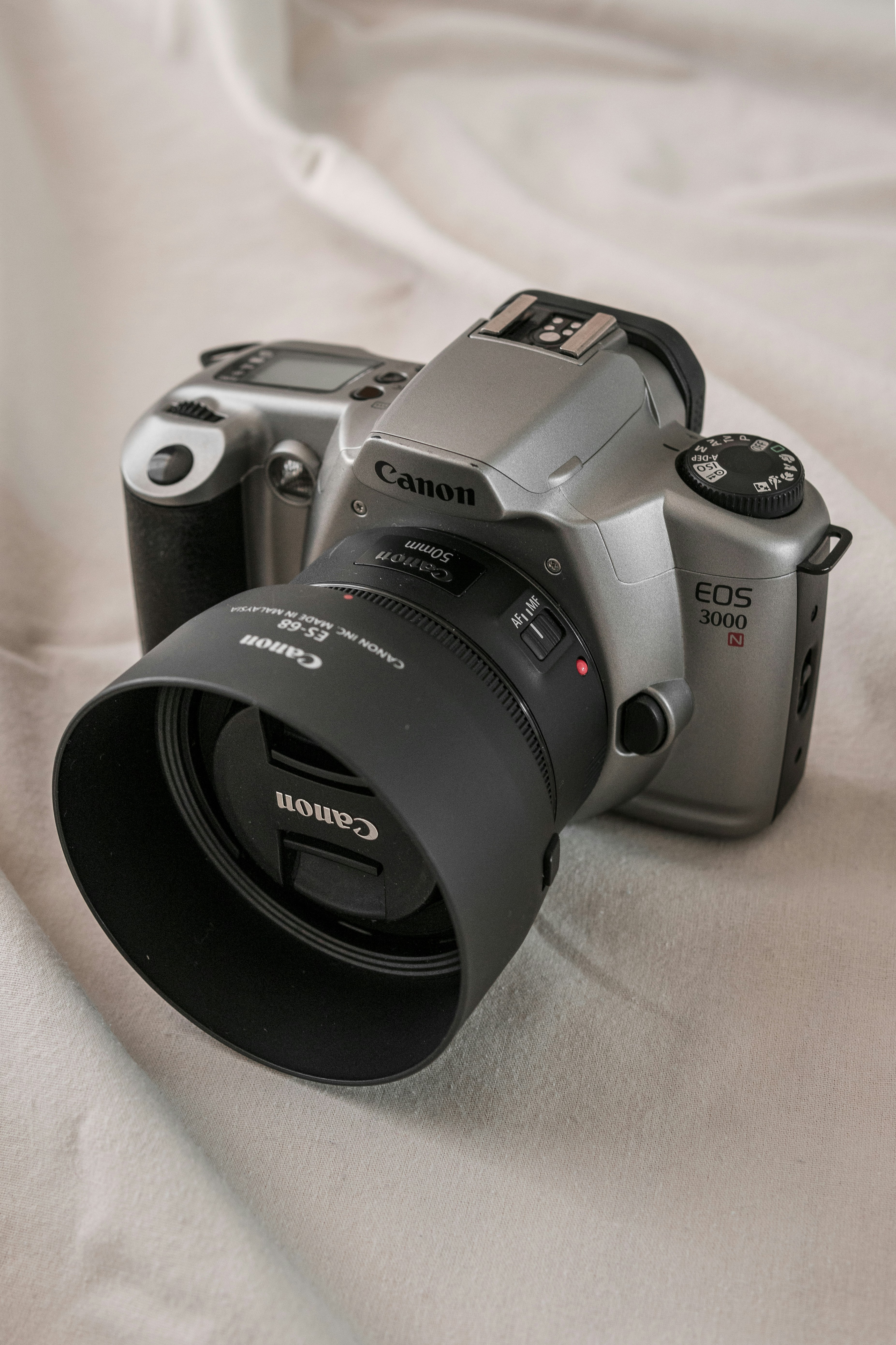 Appareil photo reflex numérique Nikon noir sur textile blanc
