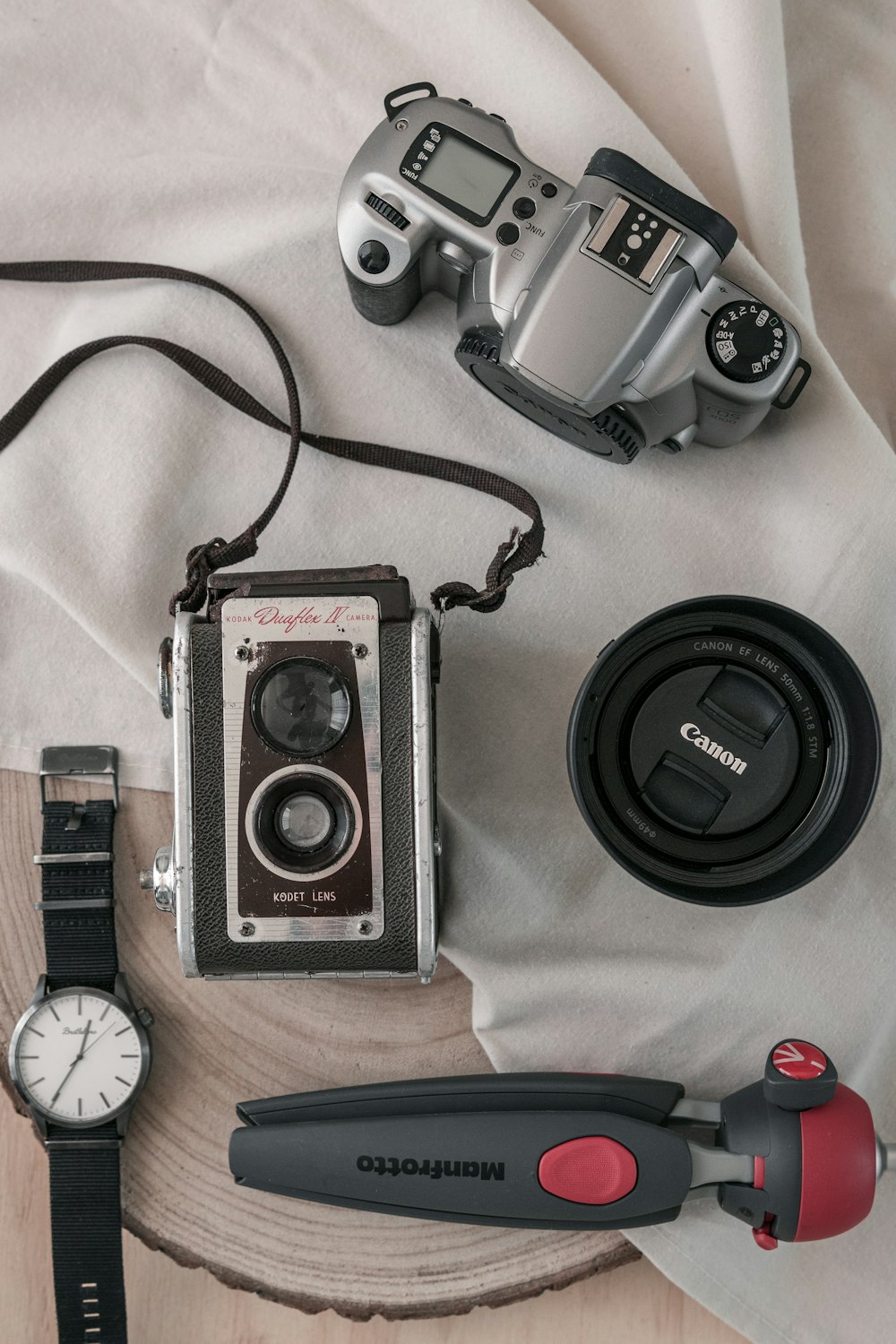 Schwarze und silberne Nikon DSLR-Kamera neben silberner runder Analoguhr