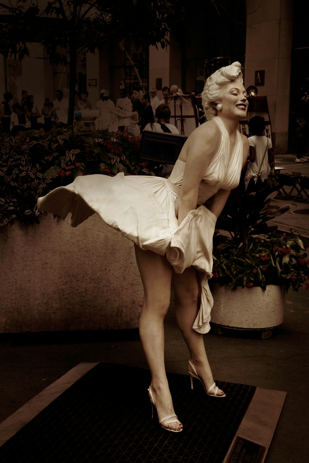 woman in white spaghetti strap dress sitting on brown wooden bench