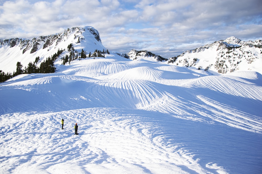 pessoas andando na montanha coberta de neve durante o dia