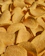 Close-up of golden, crispy banana chips spilling out of a rustic basket.