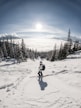 person in red jacket and blue pants riding ski blades on snow covered ground during daytime