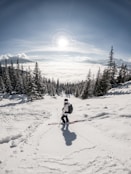 person in red jacket and blue pants riding ski blades on snow covered ground during daytime