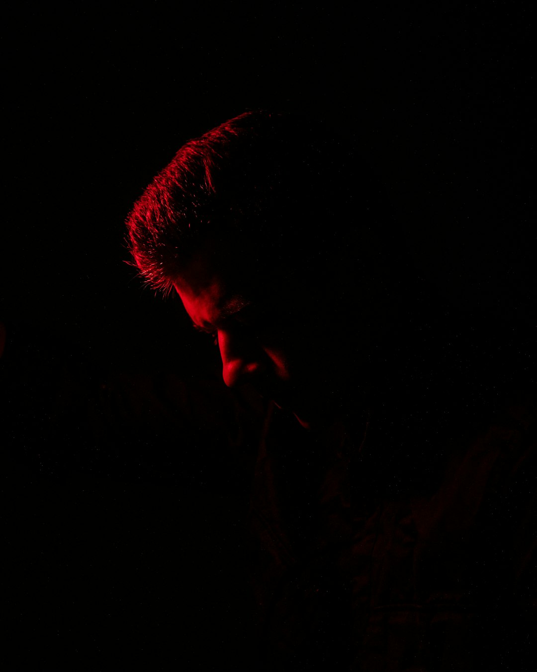 silhouette of man with red light on his face