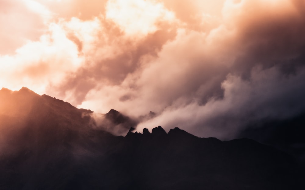 white clouds over mountain during daytime