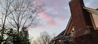 Nighttime view of a well-lit roof and chimney, showcasing quality work visible even after dark.