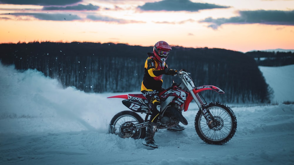 man in red and black motocross suit riding on red and white motocross dirt bike