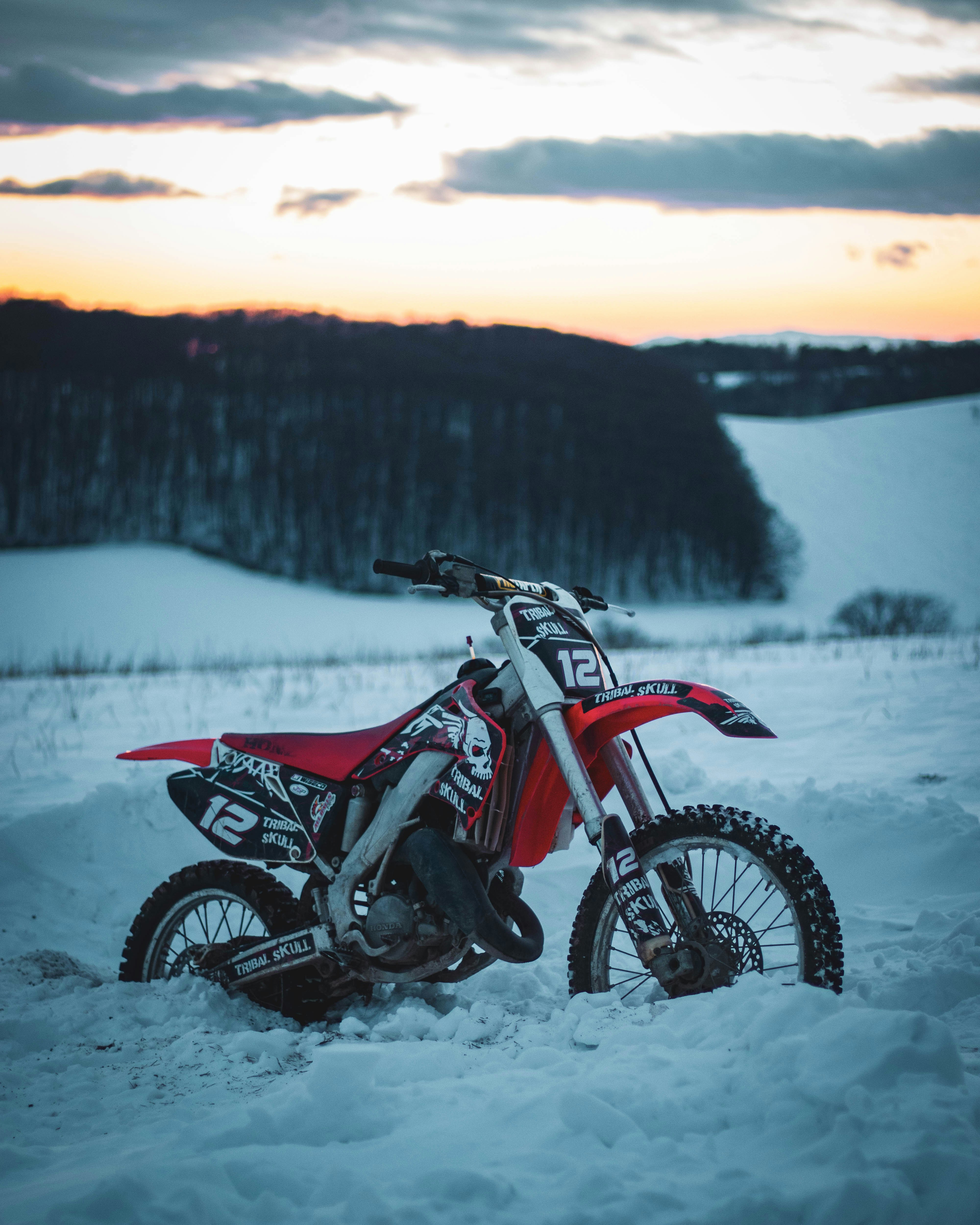Red and black motocross dirt bike on snow covered ground during ...