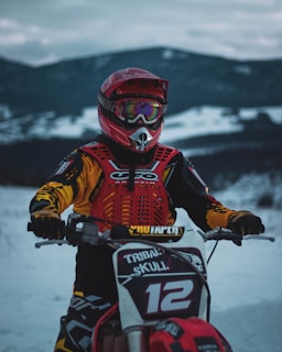 Rider wearing a colorful balaclava with a mountain backdrop at sunset.