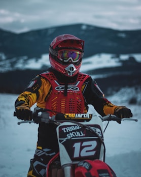 Rider wearing a colorful balaclava with a mountain backdrop at sunset.