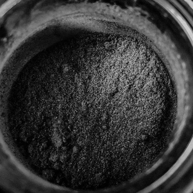 Close-up of a jar of pure creatine powder with a Mexican flag in the background