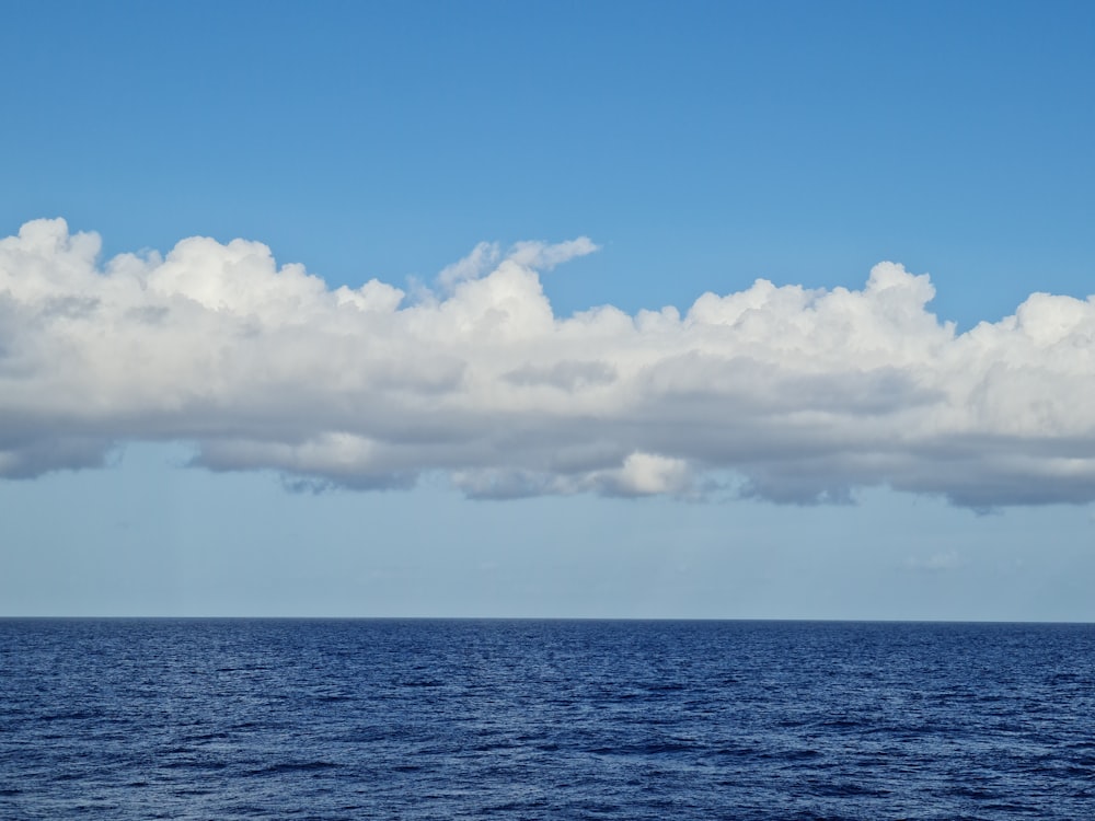 blue ocean under white clouds and blue sky during daytime