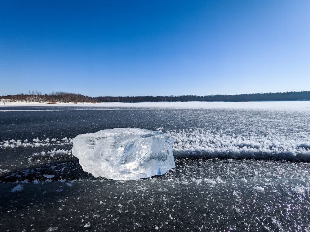 ice on black sand near body of water during daytime