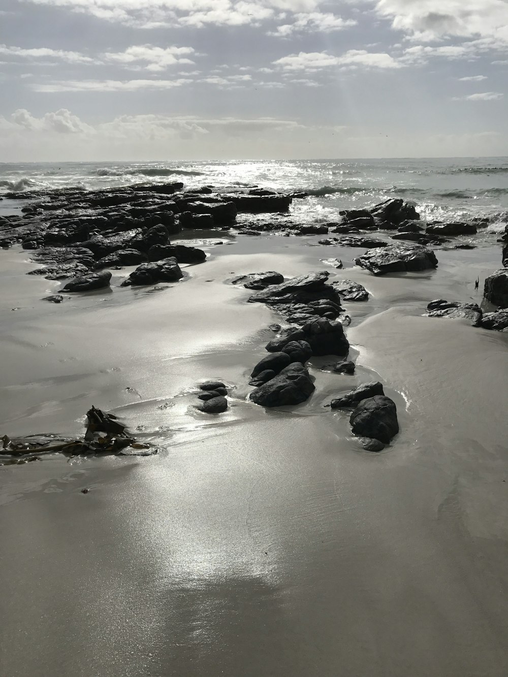 black rocks on sea shore during daytime