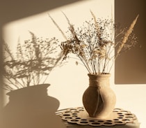 brown ceramic vase on white and black table cloth