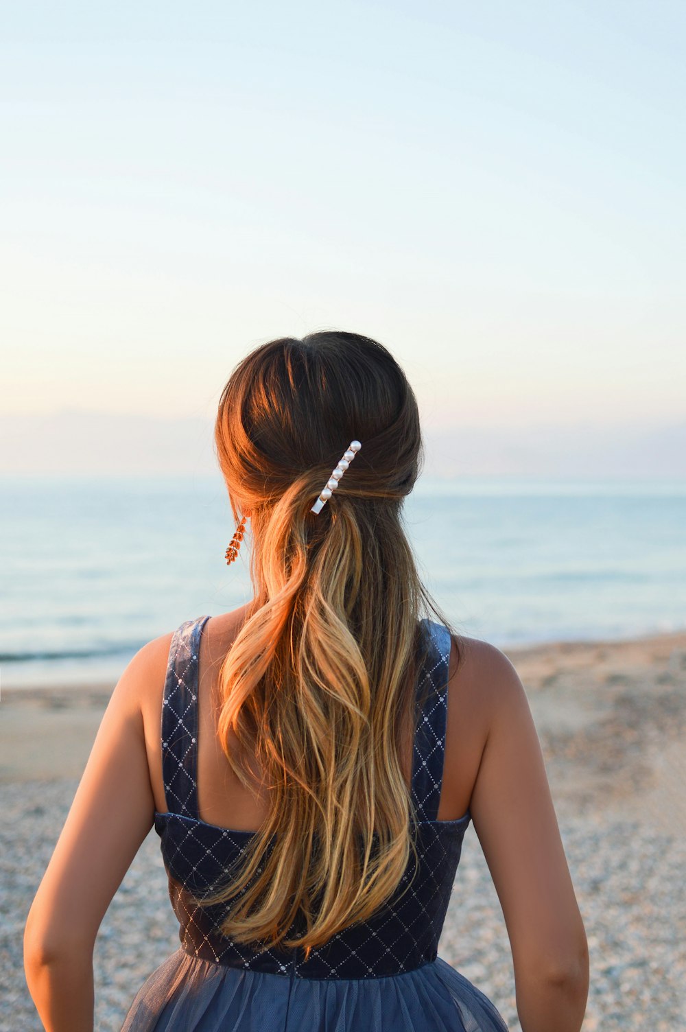 woman in black and white polka dot tank top standing on beach during daytime