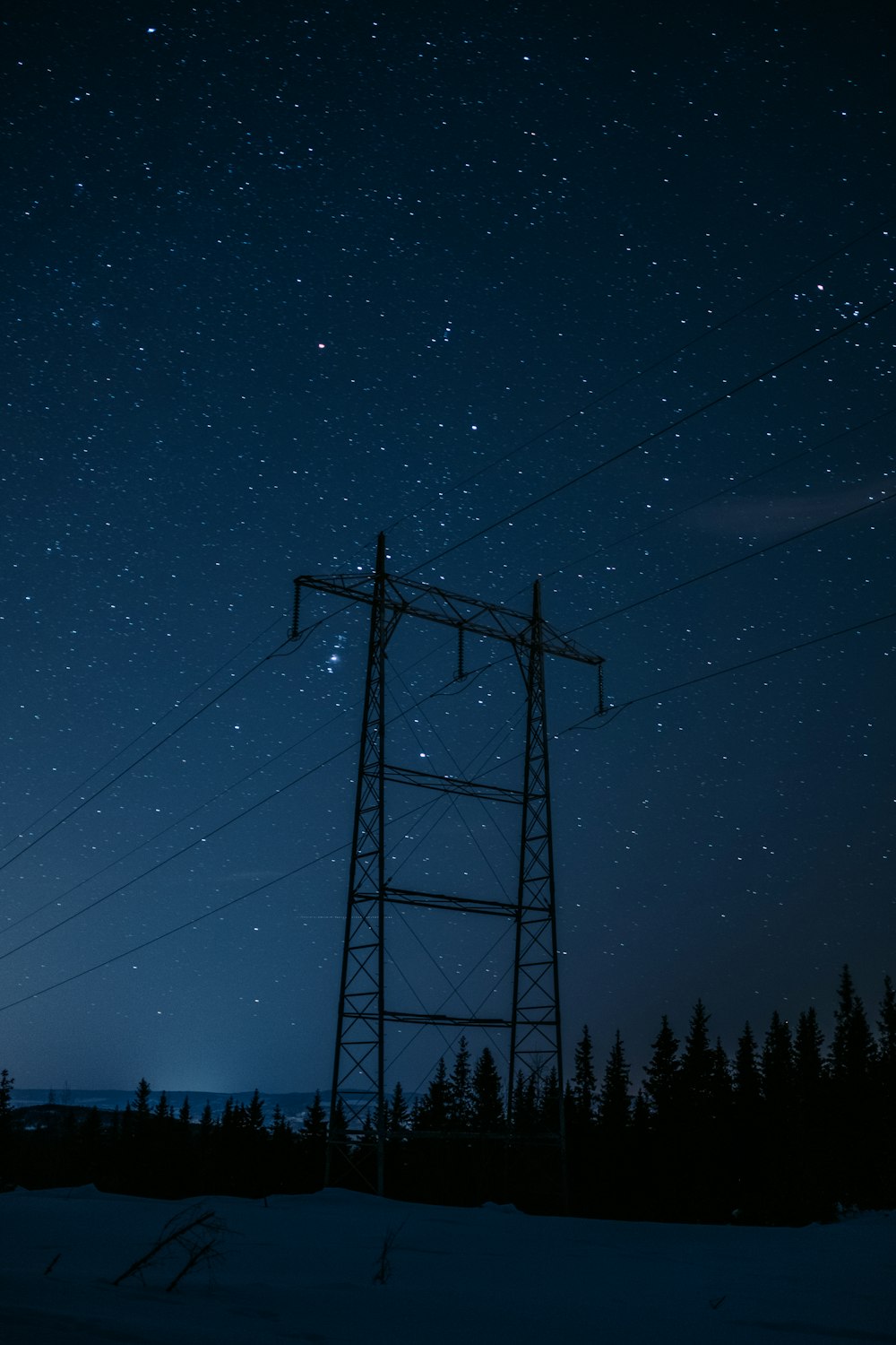 black electric post under blue sky during night time