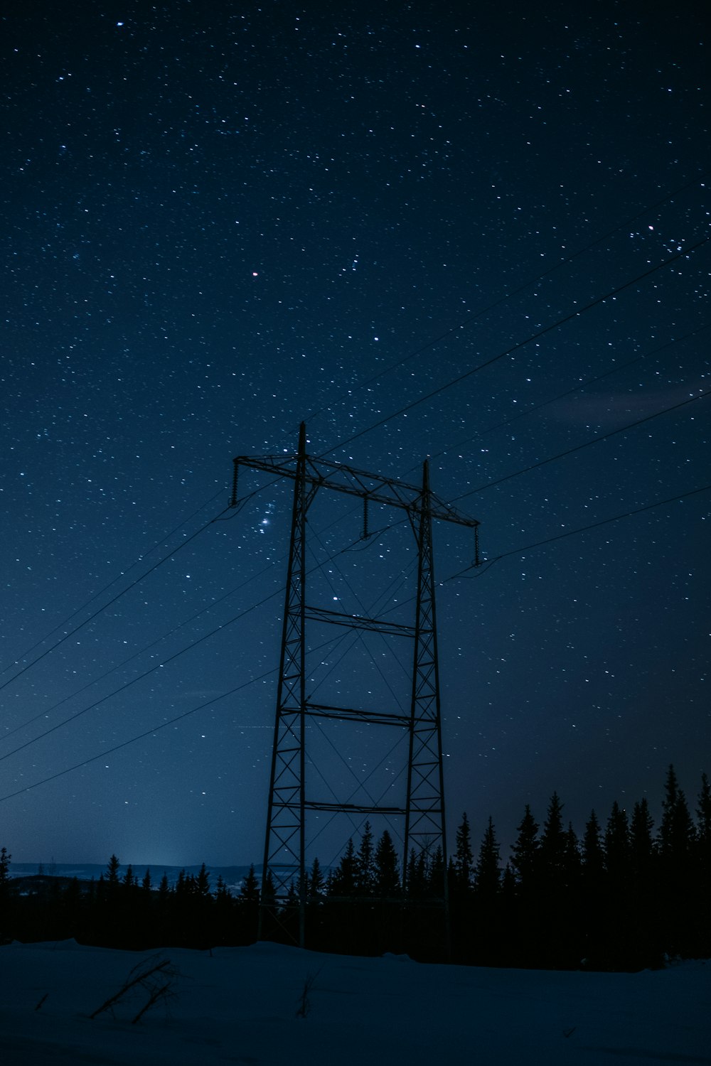 schwarzer Strommast unter blauem Himmel während der Nacht