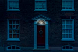Crisp, high-contrast shot of a contemporary home’s facade with striking red door and black trim details.