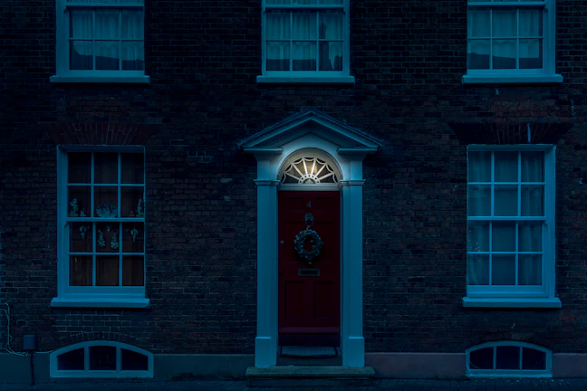 Crisp, high-contrast shot of a contemporary home’s facade with striking red door and black trim details.