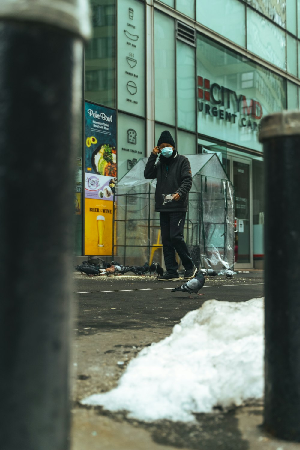 man in black jacket and black pants walking on snow covered road during daytime