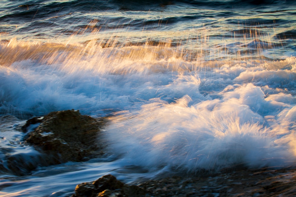 water waves hitting rocks during daytime