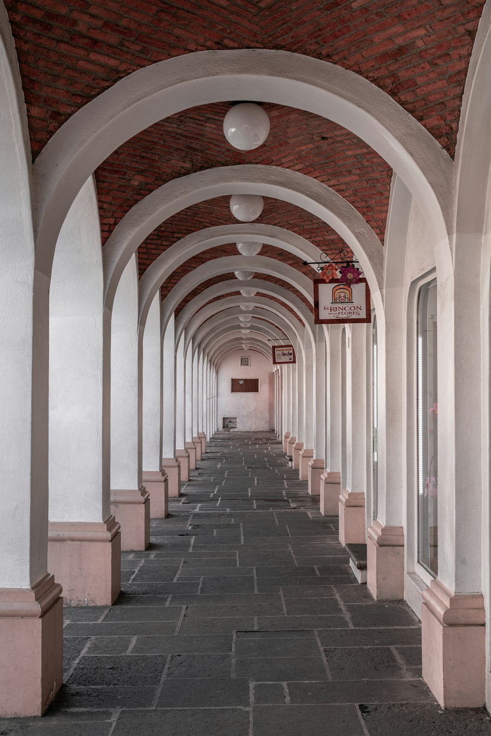 white and brown hallway with red and white brick walls