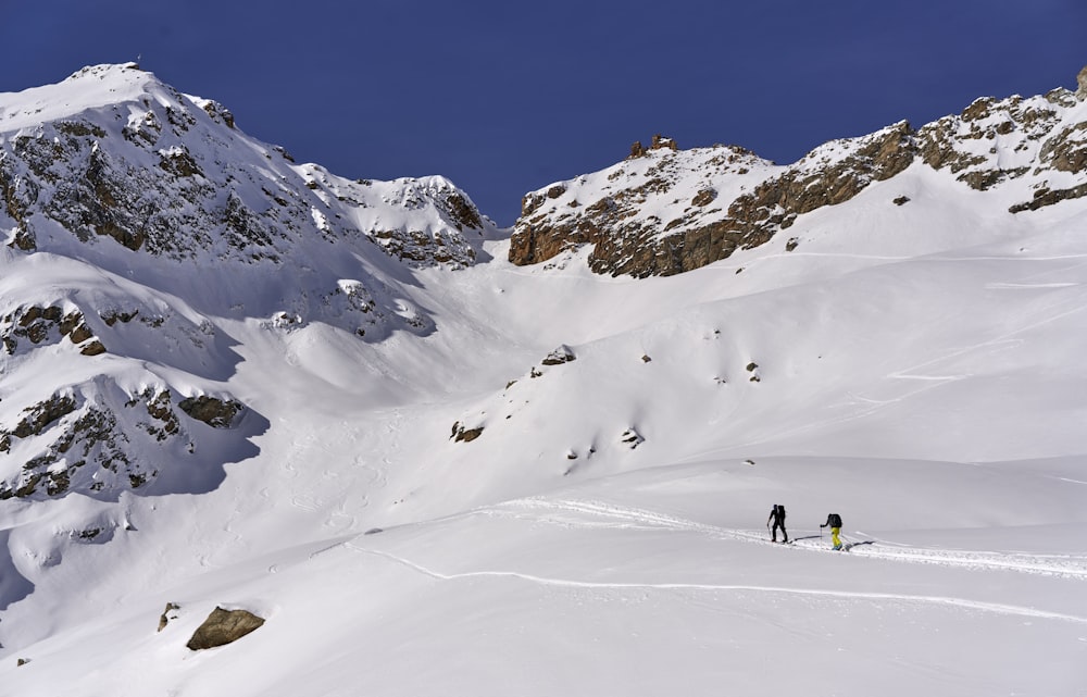 pessoas andando na montanha coberta de neve durante o dia
