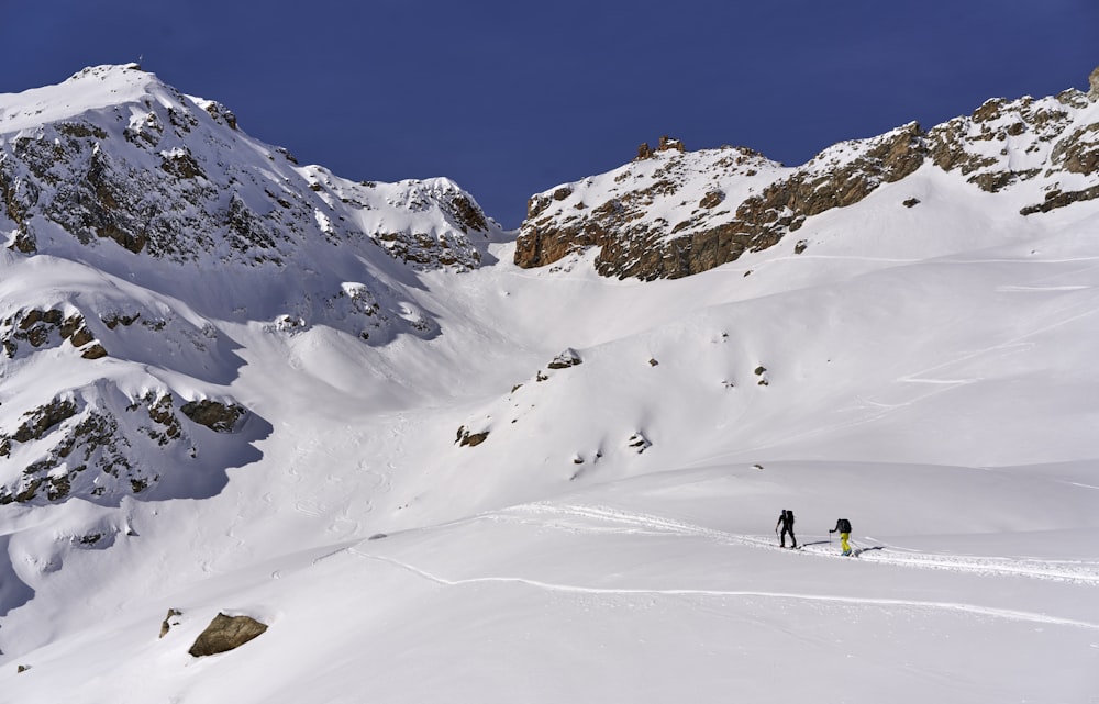 Menschen, die tagsüber auf schneebedeckten Bergen spazieren gehen