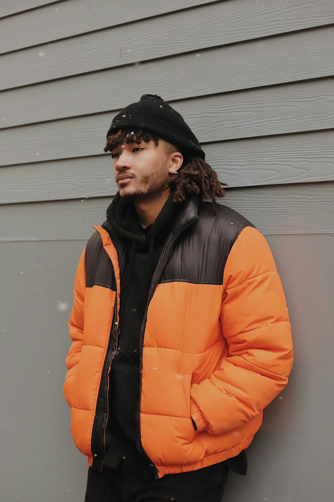 woman in orange jacket and black knit cap