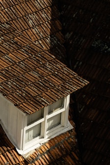 brown roof near white wooden window