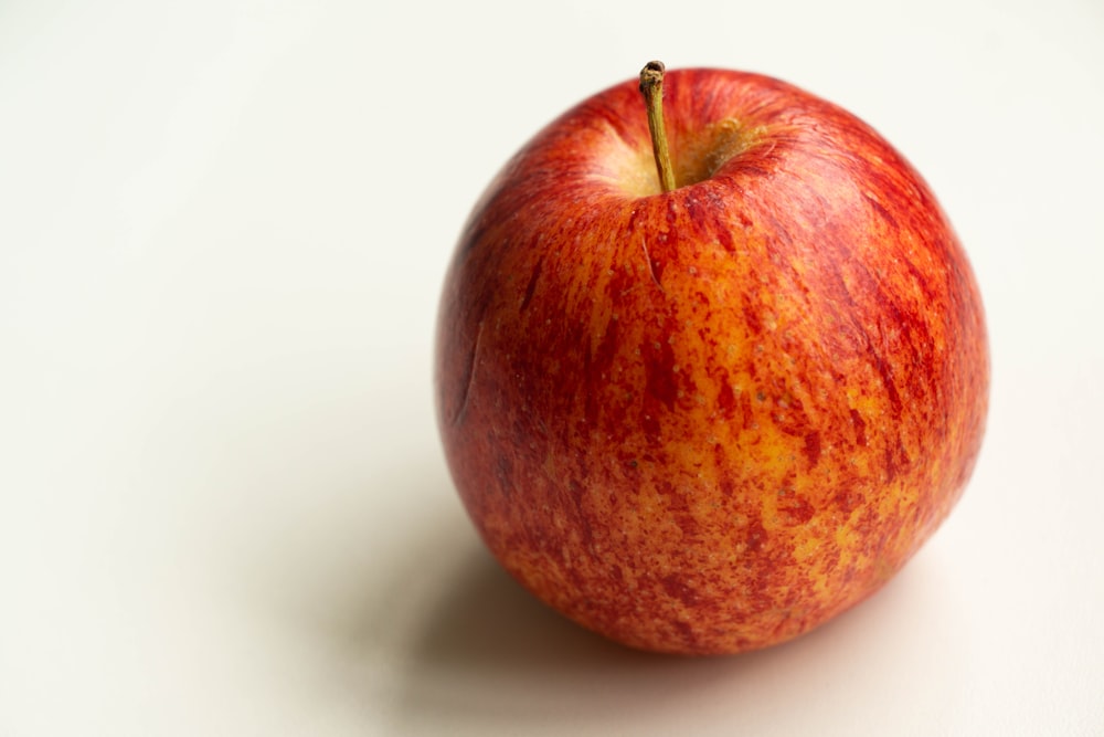 red apple fruit on white table