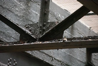 Close-up of laser cleaning rust off a steel beam on an active construction site.