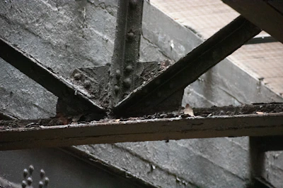 Close-up of laser cleaning rust off a steel beam on an active construction site.
