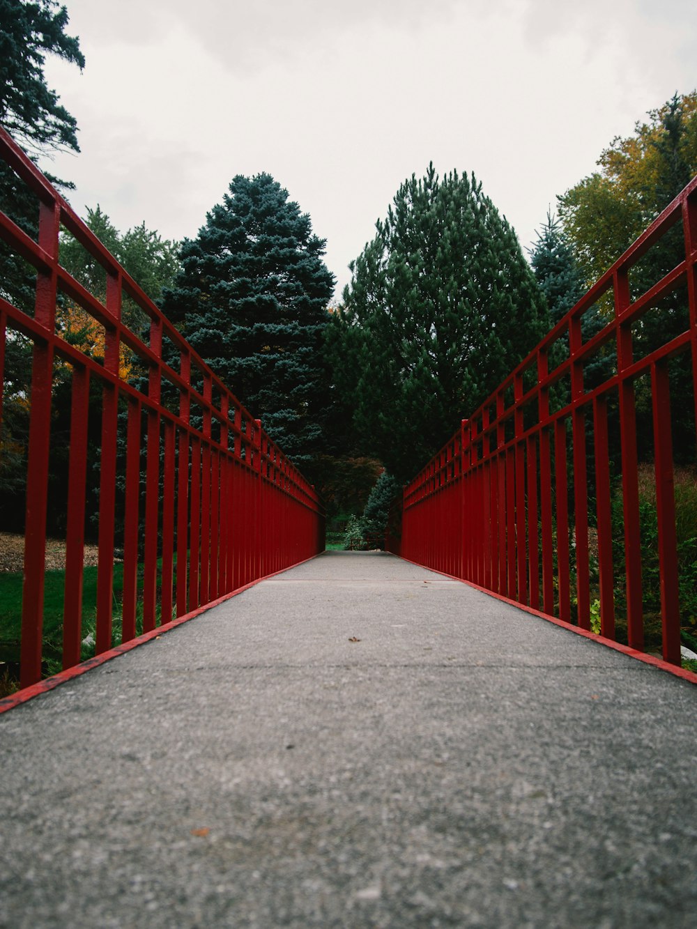 valla de madera roja cerca de árboles verdes durante el día