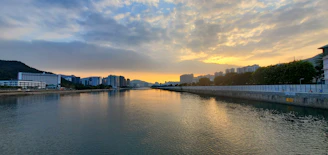 The calm waters of the Ubangi River flowing gently beside the city of Bangui at sunset.