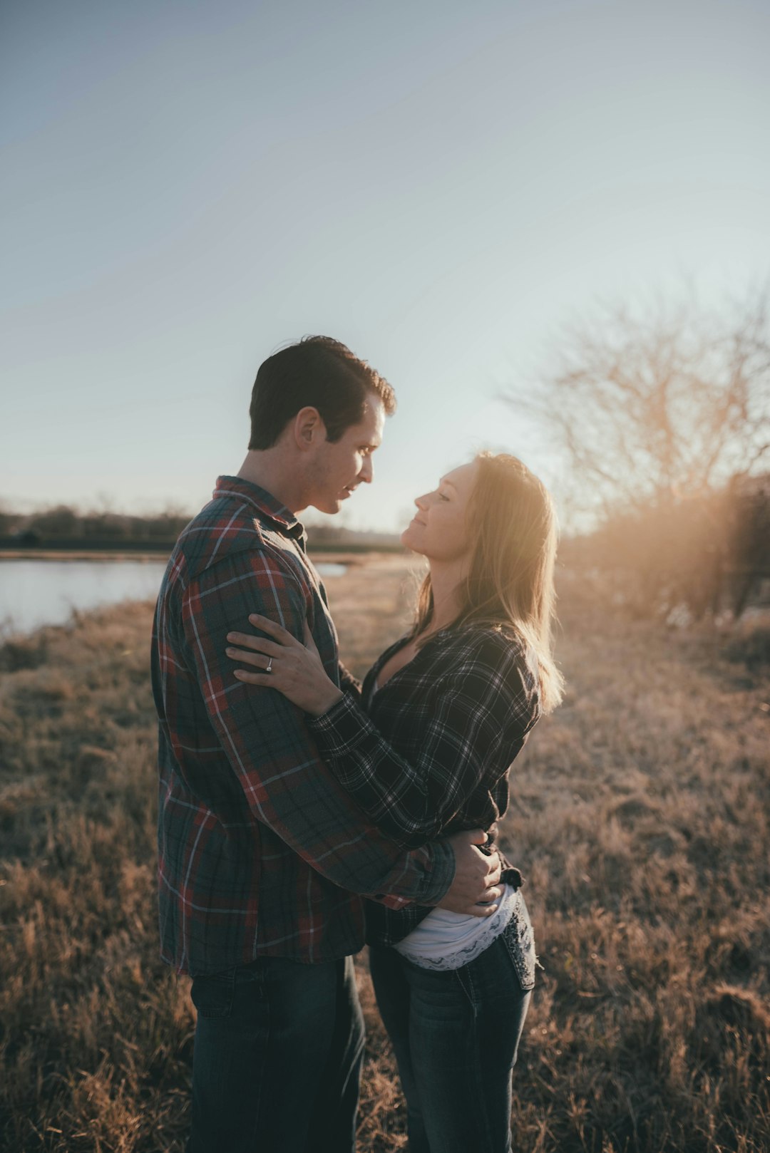 man and woman kissing near body of water during daytime