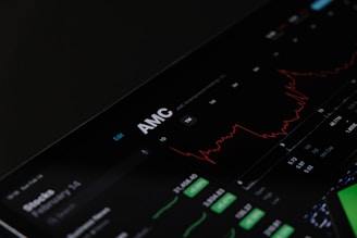 A digital stock trading interface with the focus on AMC Entertainment Holdings, Inc. The screen displays various financial data including stock prices, volume, and market cap. A red line graph shows stock performance over time and several buttons allow for different time frame selections like 1W, 1M, and 1Y. Various stock metrics appear in rows and columns.