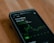 A smartphone displays stock market information, specifically for GameStop, highlighting the current price and a green graph indicating stock fluctuations.
