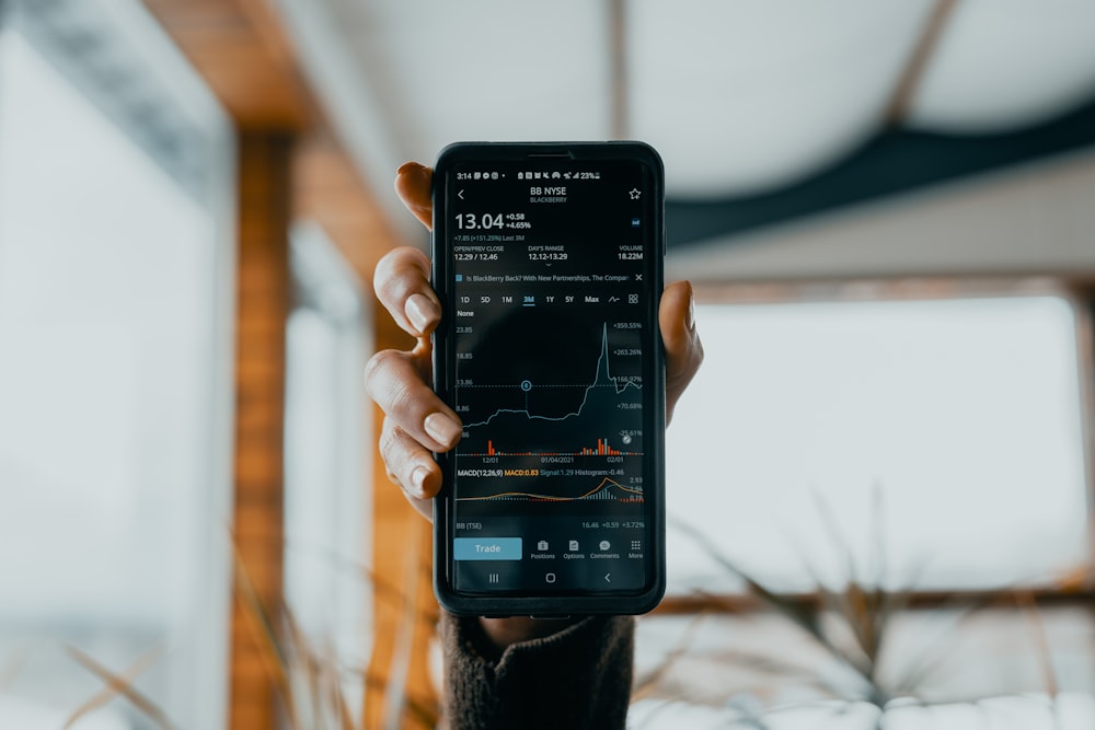 Persona sosteniendo un teléfono inteligente Samsung Android negro
