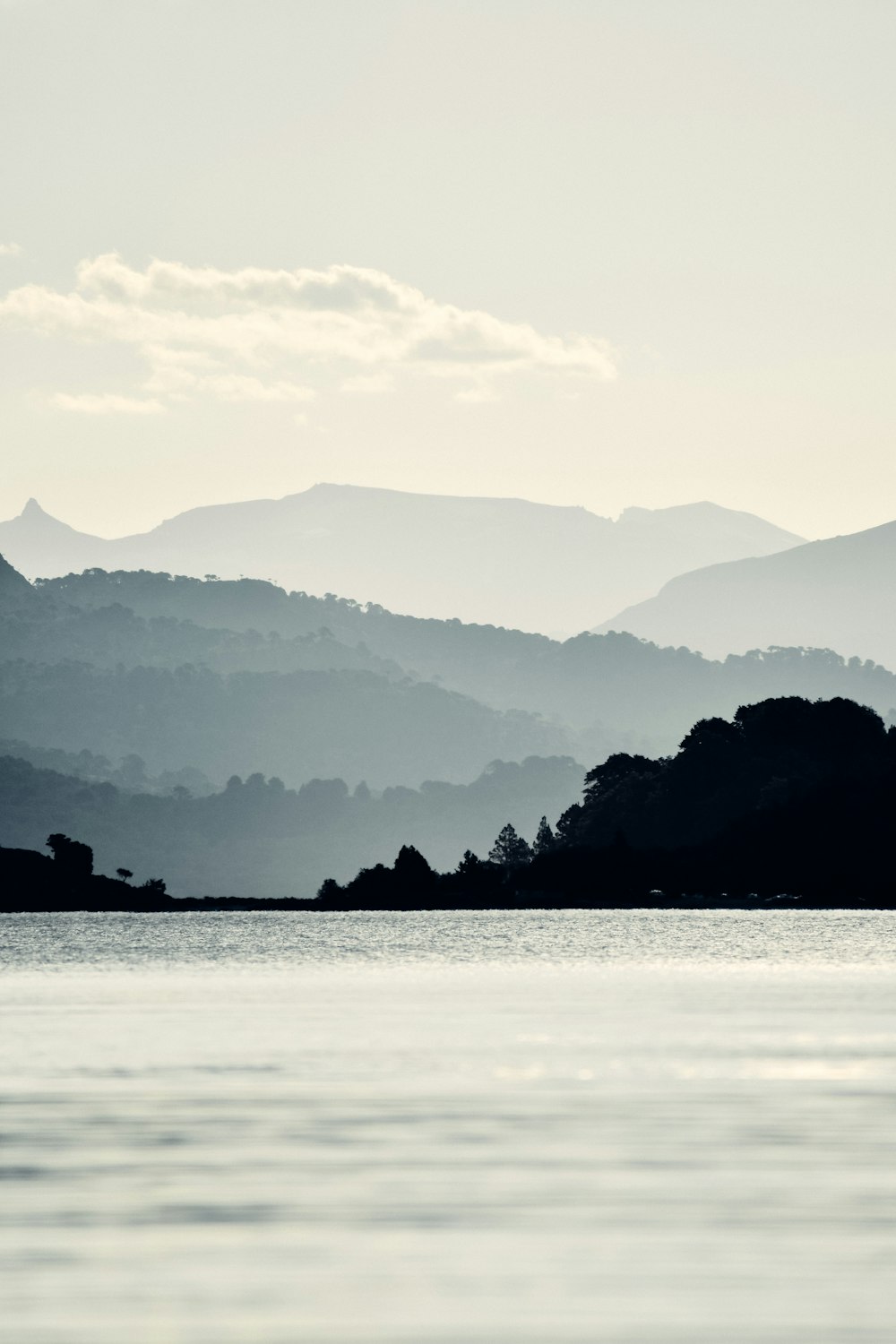 silhouette of mountain near body of water during daytime